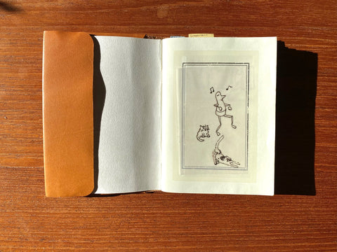 Open book with a black and white illustration on a wooden surface